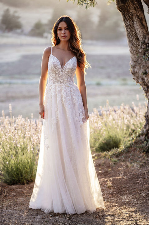 outdoor photo of woman wearing white allure romance designer wedding dress