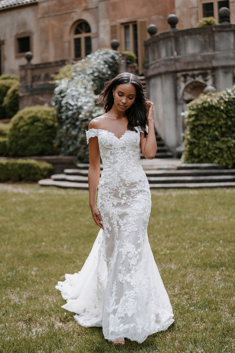 outdoor photo of woman wearing white allure romance designer wedding dress