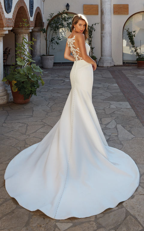 outdoor photo of woman wearing white designer eddy k wedding dress